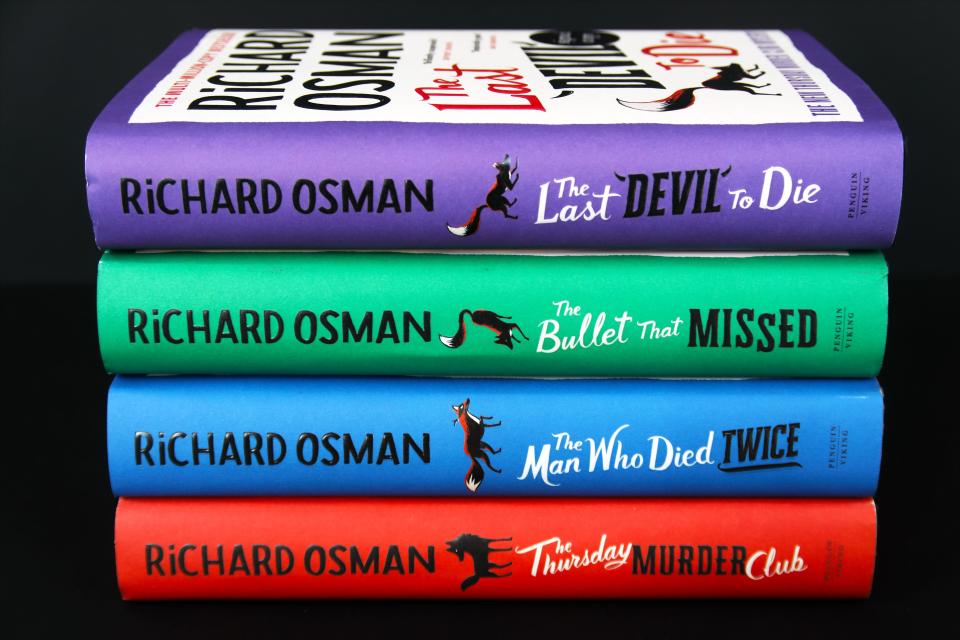 Four of Richard Osman's books stacked on top of each other.