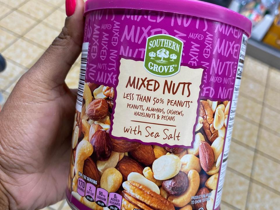 hand holding up a jar of aldi's mixed nuts