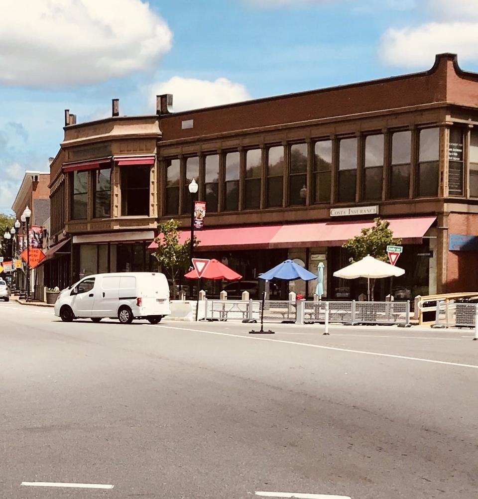 City officials say a temporary seating area in downtown Taunton. is an experiment that is being done to determine if it encourages people to visit nearby shops.