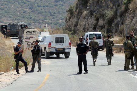 Israeli forces gather at the scene of an attack near the Jewish settlement of Dolev in the Israeli-occupied West Bank