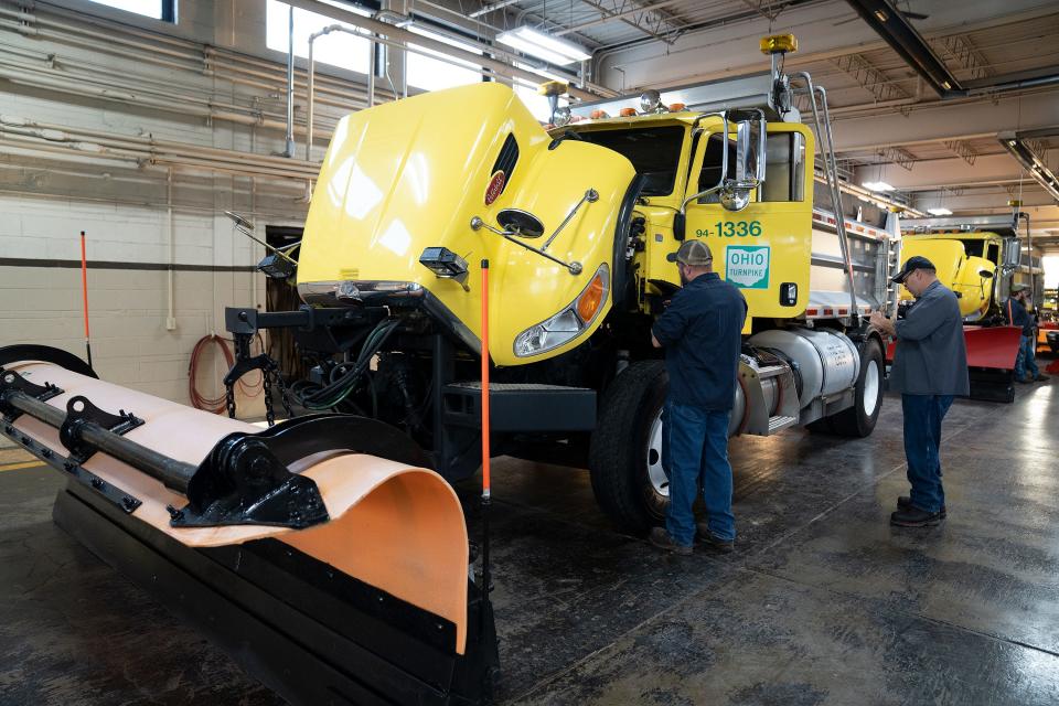 Ohio Turnpike staff inspect a snowplow truck at the Elmore Maintenance Building in Ottawa County on Friday.
