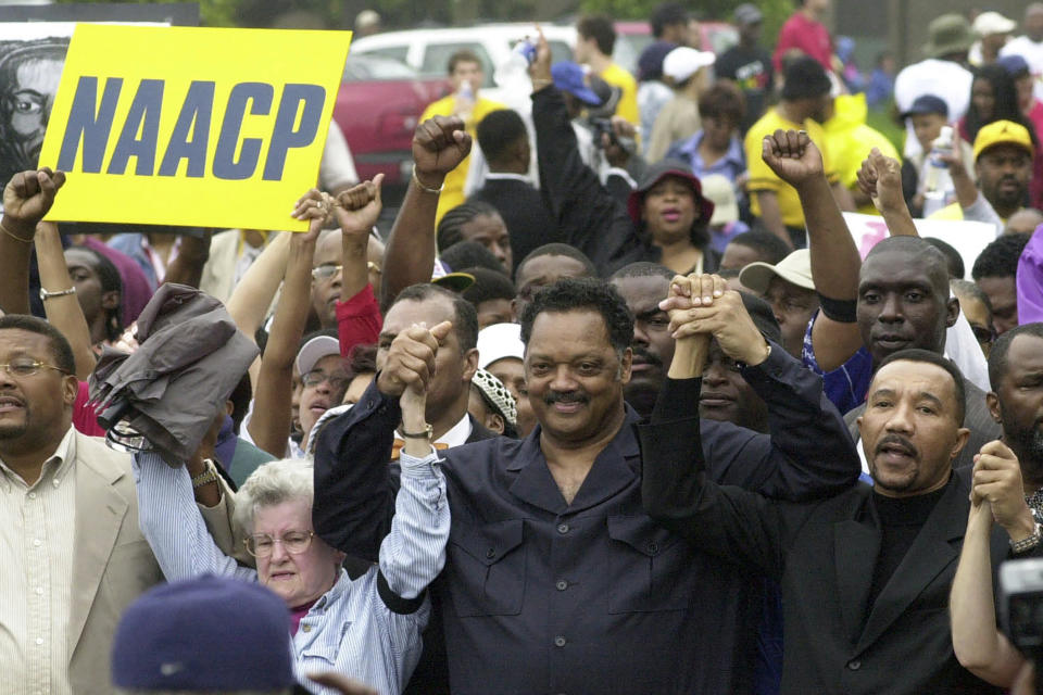 FILE - Jesse Jackson, center ,founder of Rainbow PUSH and NAACP president Kweisi Mfume, right, join hands as they arrive at Greenville County Square for a rally in a Dignity Day march, May 17, 2003, in Greenville, S.C. Jackson plans to step down from leading the Chicago civil rights organization Rainbow PUSH Coalition he founded in 1971. (AP Photo/Mary Ann Chastain, File)
