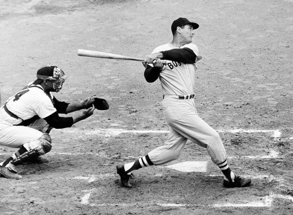 FILE - In this April 18, 1960, file photo, Ted Williams of the Boston Red Sox knocks the ball out of the park for a home run in the second inning against the Washington Senators. The Washington catcher is Earl Battey. A new film explores the life of baseball legend Williams who struggled with his Mexican-American heritage and his volatile relationship with his family and the press. The upcoming PBS 