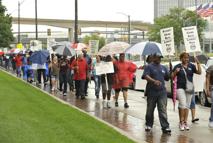 Detroit Police officers Antaeus Evans and Amber Taylor lead protest march around the Coleman Young Municipal Center Thursday, July 26, 2012 in Detroit. Detroit police officers, firefighters and other municipal union members picketed around City Hall Thursday to protest of a 10-percent pay cut and changes in health care benefits under contracts imposed by Mayor Dave Bing. (AP Photo/The Detroit News,John T. Greilick) DETROIT FREE PRESS OUT; HUFFINGTON POST OUT