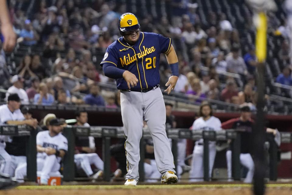 An injured Milwaukee Brewers' Daniel Vogelbach limps to home plate to score a run against the Arizona Diamondbacks during the sixth inning of a baseball game Tuesday, June 22, 2021, in Phoenix. (AP Photo/Ross D. Franklin)