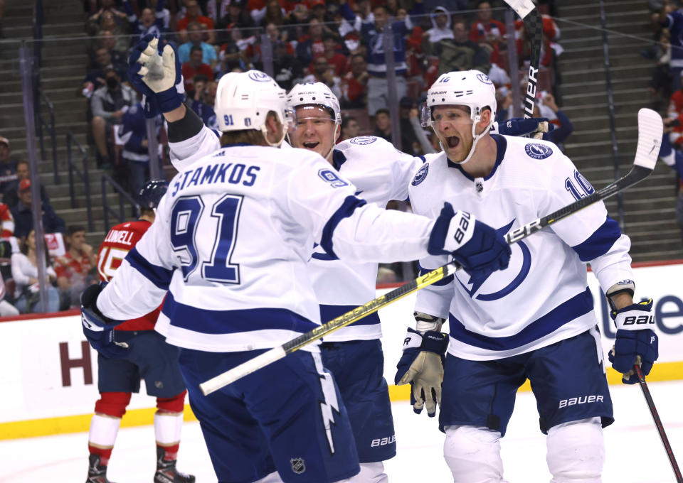 Tampa Bay Lightning center Steven Stamkos (91), right wing Corey Perry (10) and left wing Ondrej Palat (18) celebrate a goal against the Florida Panthers during the first period of Game 2 of an NHL hockey second-round playoff series Thursday, May 19, 2022, in Sunrise, Fla. (AP Photo/Reinhold Matay)