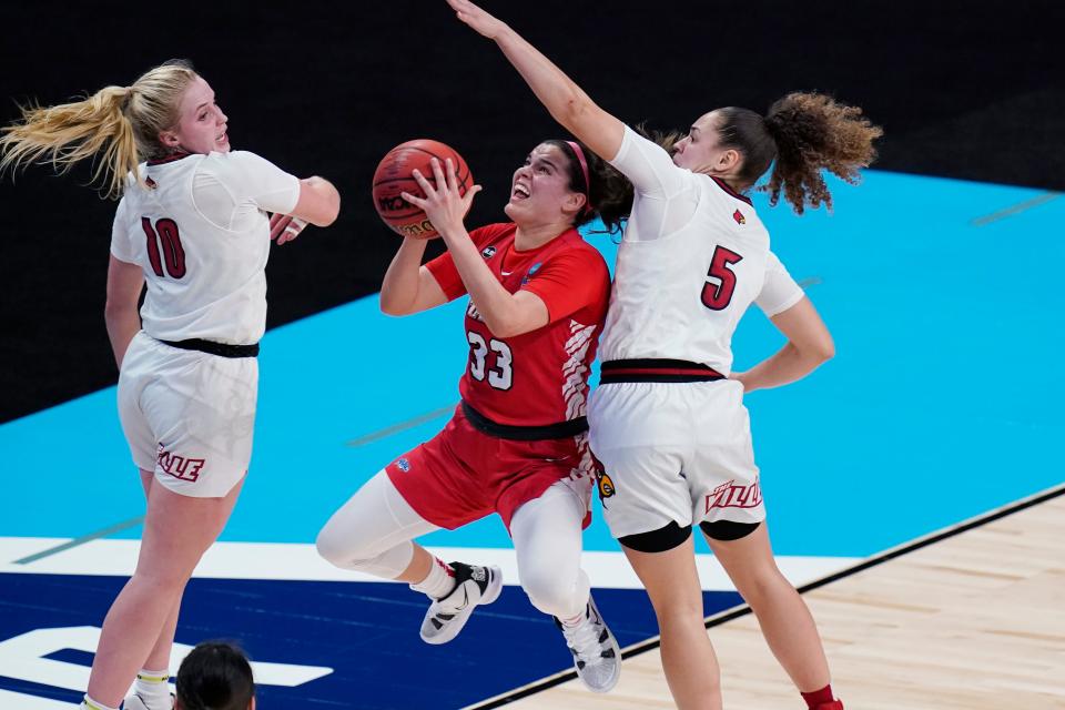 Marist guard Kendall Krick drives to the basket against Louisville's Hailey Van Lith, left, and guard Mykasa Robinson during the first round of the NCAA women's basketball tournament at the Alamodome in San Antonio on March 22, 2021.