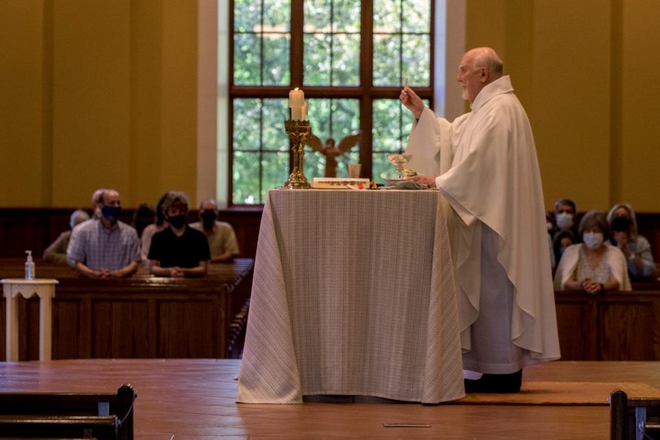 Monsignor Paul Enke prepares communion at Mass at St. Edward the Confessor Church in 2020. Enke will retire after 23 years as the church's pastor following a final service July 9.