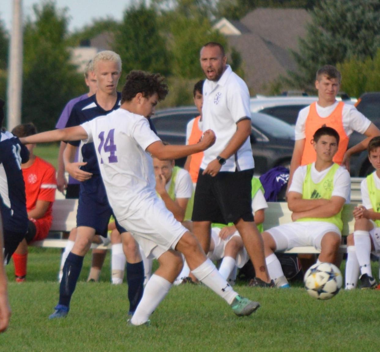 Corbin Calvert (standing in front of the bench) looks on during a Bloomington South boys soccer game. Calvert was promoted to Panthers head coach ahead of the 2022 season.