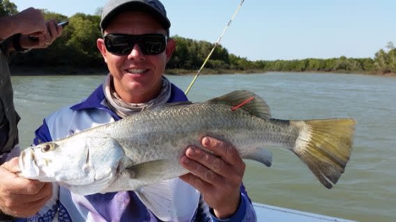 Un pescador muestra un barramundi que sacó en el marco de un singular concurso de pesca en Australia. (AP)