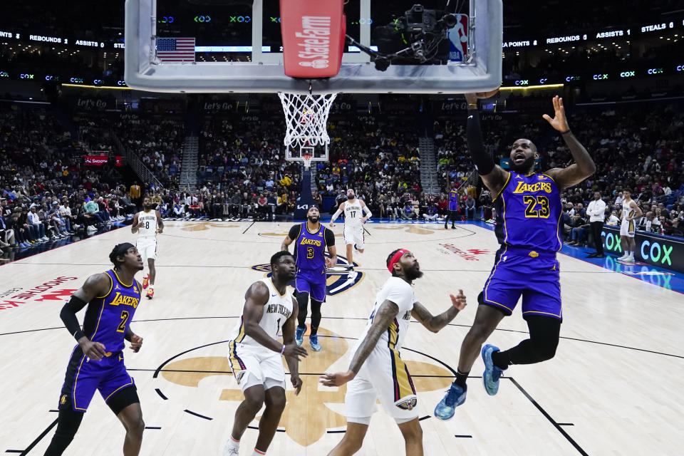 Los Angeles Lakers forward LeBron James (23) shoots over New Orleans Pelicans forward Brandon Ingram and forward Zion Williamson (1) in the first half of an NBA basketball game in New Orleans, Sunday, Dec. 31, 2023. (AP Photo/Gerald Herbert)