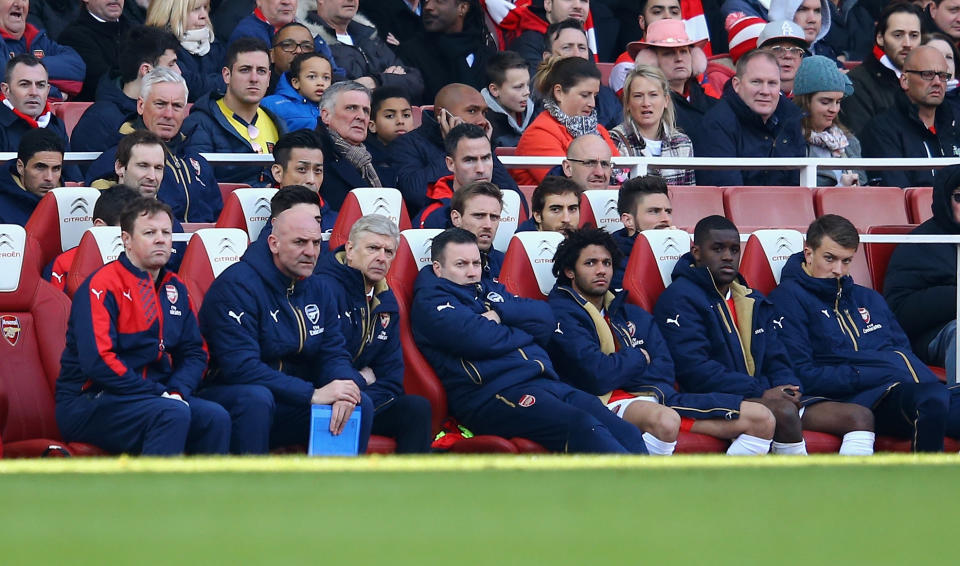 Arsene Wenger manager of Arsenal looks on from the team bench with backroom coaching staff and players during the Emirates FA Cup