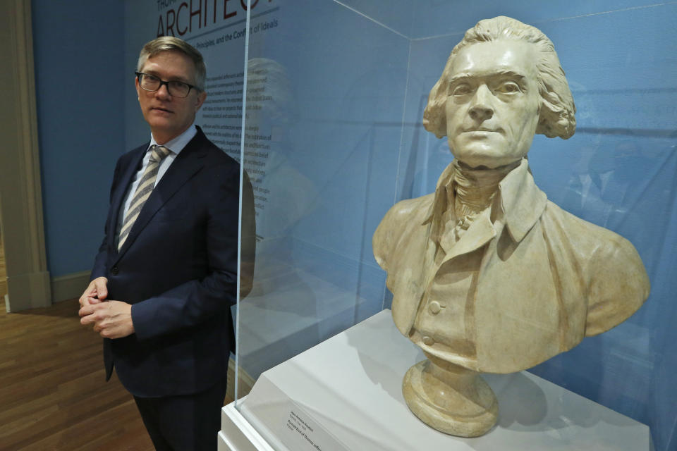 Erik H. Neil, director of the Chrysler Museum of Art, poses next to a bust of Thomas Jefferson during a tour of an exhibit titled "Thomas Jefferson, Architect: Palladian Models, Democratic Principles, and the Conflict of Ideals." At the museum in Norfolk, Va., Wednesday, Oct. 16, 2019. (AP Photo/Steve Helber)