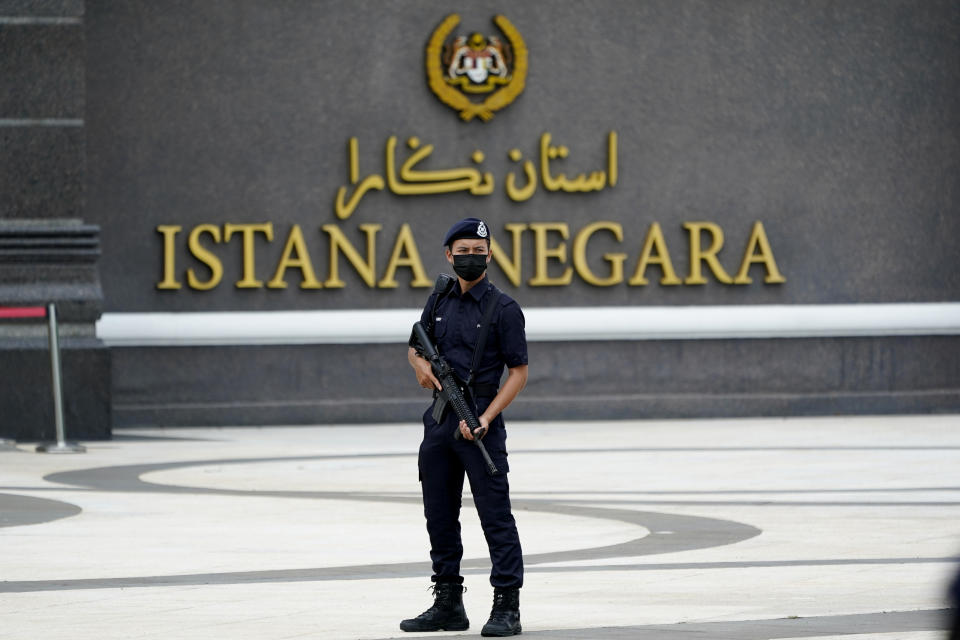 Armed police wearing a face mask to help curb the spread of the coronavirus stands outside National Palace in Kuala Lumpur, Malaysia, Sunday, Oct. 25, 2020. Malay rulers hold a special meeting on Sunday to discuss the government's plan to declare an emergency to tackle the worsening COVID-19 situation. (AP Photo/Vincent Thian)