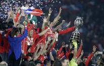 Chile players celebrate as goalie Claudio Bravo holds up the Copa America trophy during the medal presentation ceremony after they defeated Argentina in the Copa America 2015 final soccer match at the National Stadium in Santiago, Chile, July 4, 2015. REUTERS/Jorge Adorno