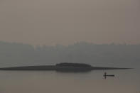 A man stands up on his boat as he fishes in the waters of the Villa Victoria Dam, the main water supply for Mexico City residents, on the outskirts of Toluca, Mexico Thursday, April 22, 2021. Drought conditions now cover 85% of Mexico, and in areas around Mexico City and Michoacán, the problem has gotten so bad that lakes and reservoirs are drying up. (AP Photo/Fernando Llano)