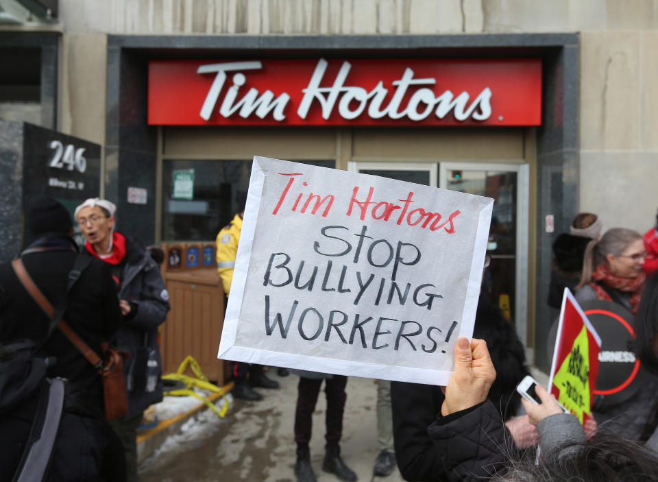 TORONTO, ON- JANUARY 10 – Protesters hold signs outside the Tim Horton’s Bloor Street West location in Toronto. (Steve Russell/Toronto Star via Getty Images)