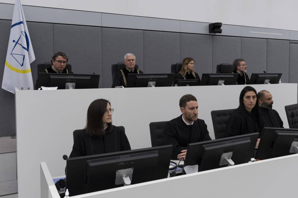 Presiding judge Mappie Veldt-Foglia, top row, second right, prepares to read the verdict in the case of Salih Mustafa, a former Kosovo rebel, at the Kosovo Specialist Chambers court in The Hague, Netherlands, Friday, Dec. 16, 2022. Mustafa is charged with the war crimes of arbitrary detention, cruel treatment, the torture of at least six people and the murder of one person at a detention compound in Zllash, Kosovo, in April 1999. Salih Mustafa pleaded not guilty to all charges. (AP Photo/Peter Dejong, Pool)
