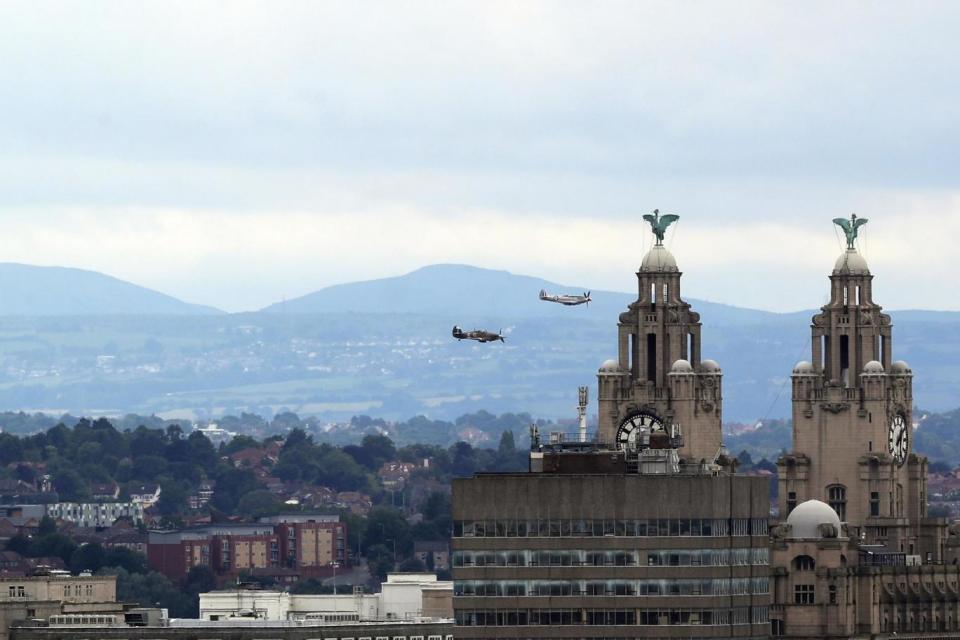 Liverpool: The Battle of Britain Memorial Flight passes the Royal Liver Buildings (PA)