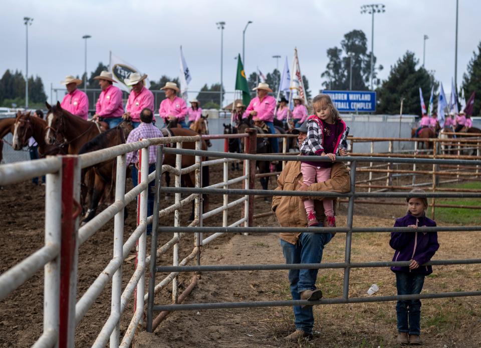 A father stands alongside his daughters for the start of the California Rodeo Salinas in Salinas, Calif., on Thursday, Sept. 23, 2021. 