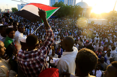 Sudanese demonstrators wave their national flags as they attend a mass anti-government protest outside Defence Ministry in Khartoum, Sudan April 21, 2019. REUTERS/Mohamed Nureldin Abdallah