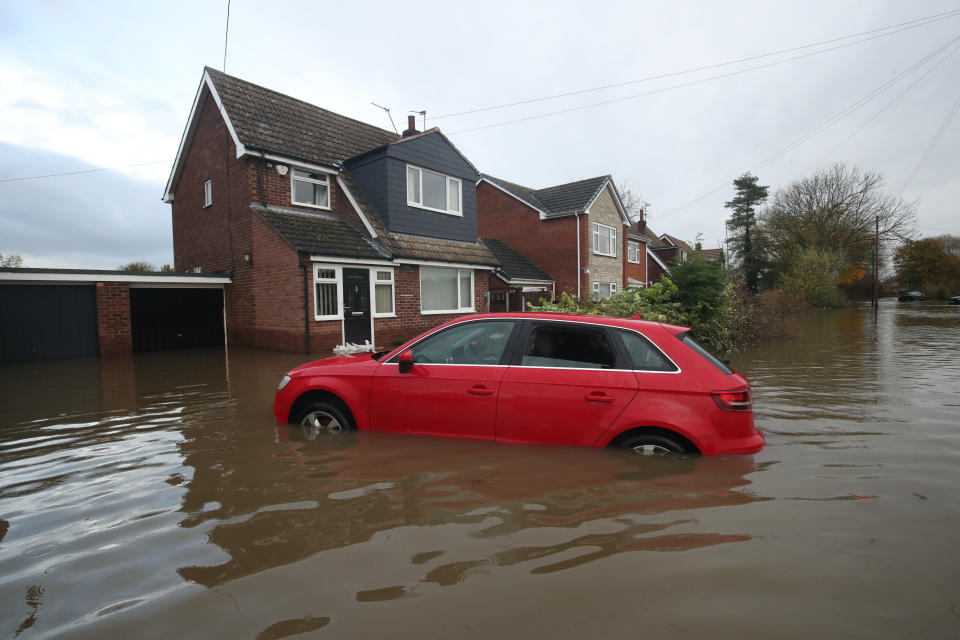 A car in floodwater outside a house in Fishlake, Doncaster. The Prime Minister is set to chair a meeting of the Government's emergency committee after severe flooding in parts of the country, where rain is finally expected to ease this afternoon.