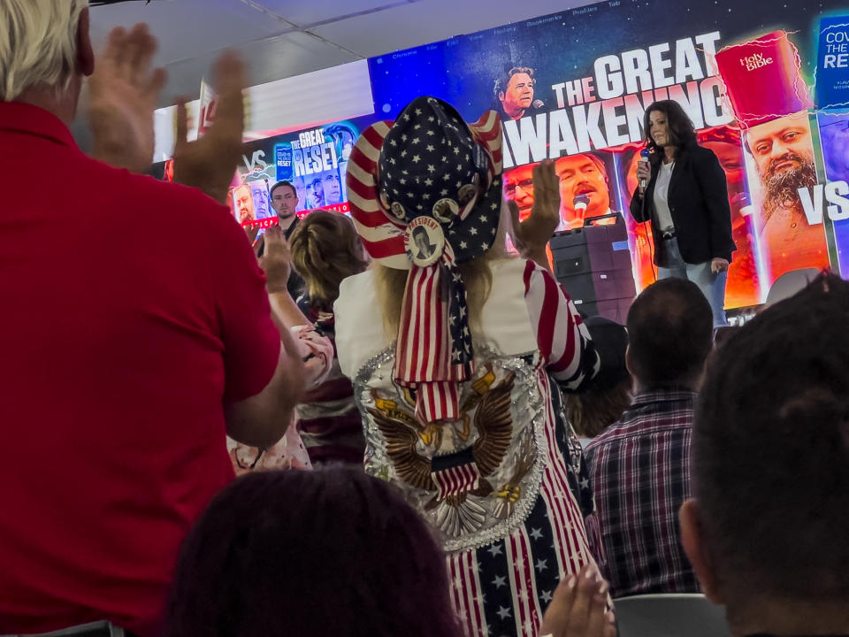 The audience stands and applauds as Christie Hutcherson speaks during the ReAwaken America Tour at Cornerstone Church in Batavia, N.Y., Friday, Aug. 12, 2022. (AP Photo/Carolyn Kaster)