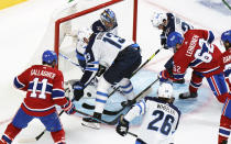 CORRECTS PHOTOGRAPHER TO PAUL CHIASSON INSTEAD OF RYAN REMIORZ - Montreal Canadiens' Artturi Lehkonen scores past Winnipeg Jets goaltender Connor Hellebuyck as Jets' Pierre-Luc Dubois(13) and Derek Forbort(24) try to defend during the second period of an NHL Stanley Cup playoff hockey game in Montreal, Sunday, June 6, 2021. (Paul Chiasson/The Canadian Press via AP)