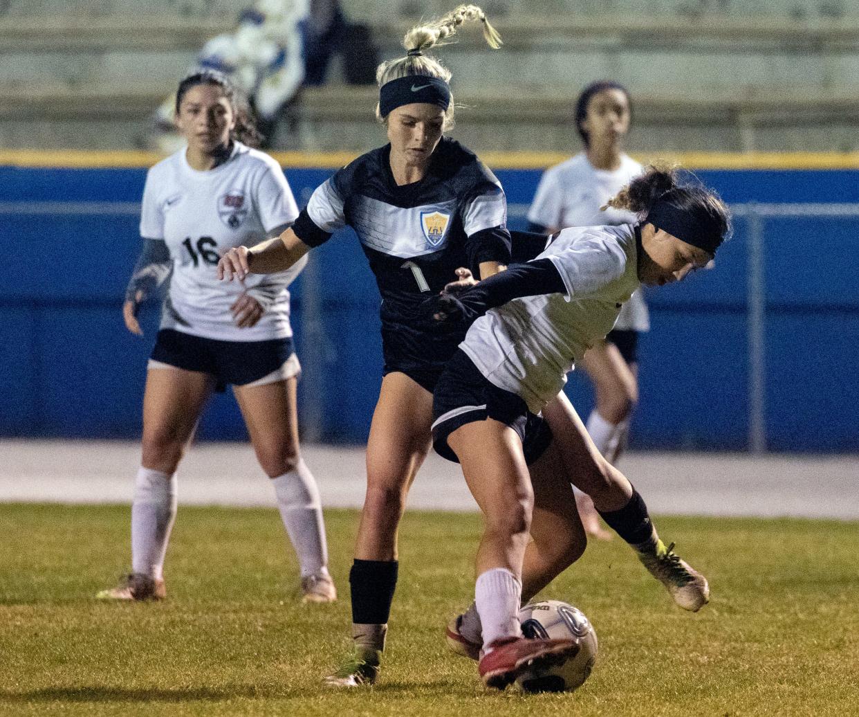 Auburndale junior Peyton Battilla (1) battles a Gateway defender for control of the ball on Wednesday night in the first round of the Class 5A, District 7 girls soccer tournament.