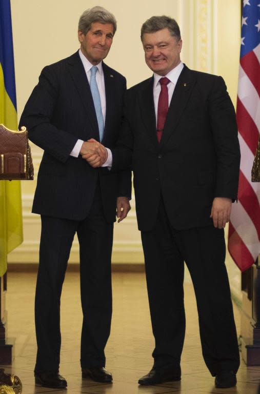 Ukrainian President Petro Poreshenko (R) shakes hands with US Secretary of State John Kerry (L) after delivering a statement following a bilateral meeting in Kiev, on February 5, 2015