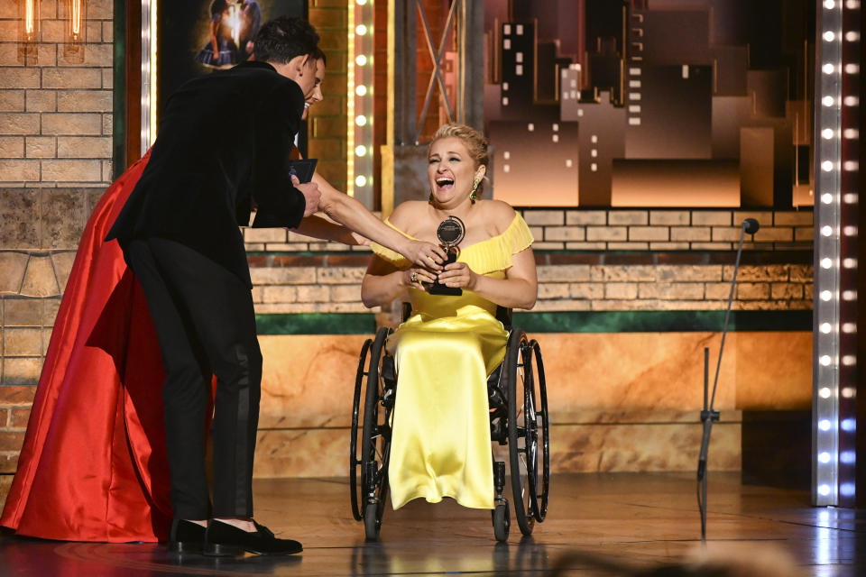 Laura Benanti, from left, and Anthony Ramos present the award for best performance by an actress in a featured role in a musical to Ali Stroker for her performance in "Rodgers & Hammerstein's Oklahoma!" at the 73rd annual Tony Awards at Radio City Music Hall on Sunday, June 9, 2019, in New York. (Photo by Charles Sykes/Invision/AP)