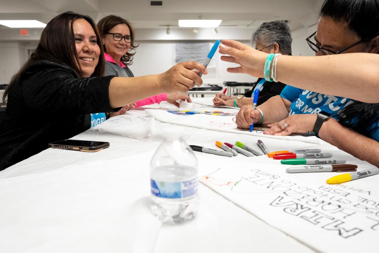 Elizabeth Becerra, left, a bilingual outreach worker for Justice for Migrant Women, passes a blue colored sharpie to another guest creating bandanas during The Bandana Project, an advocacy project to raise awareness about workplace sexual violence against women farmworkers in the United States.