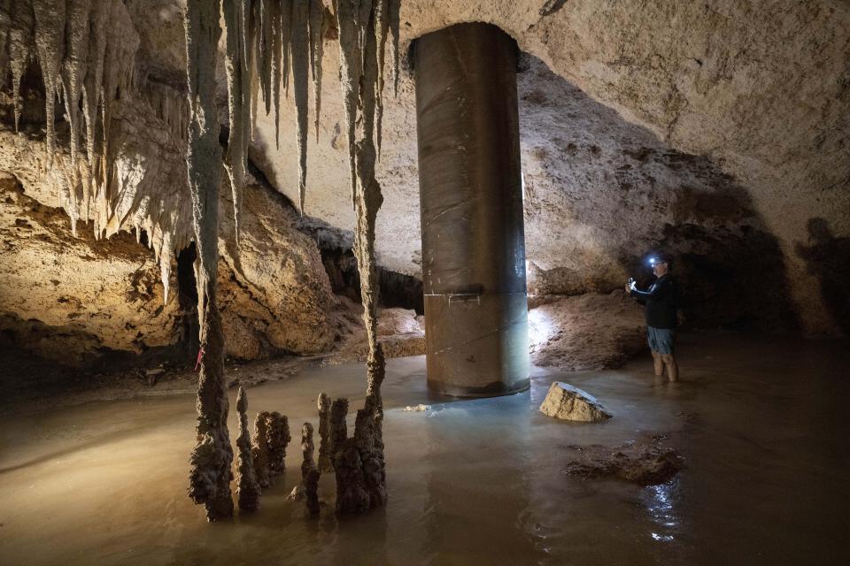 El ingeniero Guillermo D. Christy fotografía una columna de acero rellena de concreto instalada para proporcionar apoyo a una parte de la vía del Tren Maya, dentro del sistema de cavernas Aktun Tuyul, el domingo 3 de marzo de 2024, en las afueras de Playa del Carmen, México. La construcción de este ferrocarril en la península mexicana de Yucatán está destruyendo rápidamente muchas de las cavernas subterráneas y depósitos de agua, llamados cenotes, que ya se encuentran amenazados por el desarrollo y el turismo masivo. (AP Foto/Rodrigo Abd)