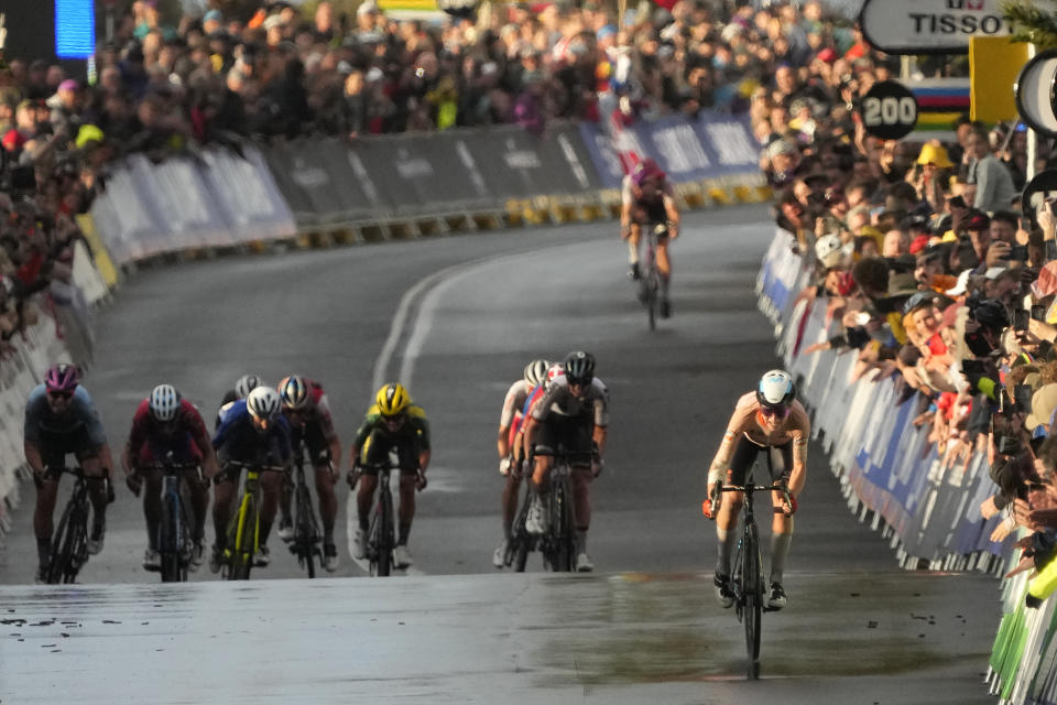 Annemiek van Vleuten of Netherlands, right, races to the finish line to win the elite women's road race at the world road cycling championships in Wollongong, Australia, Saturday, Sept. 24, 2022. (AP Photo/Rick Rycroft)