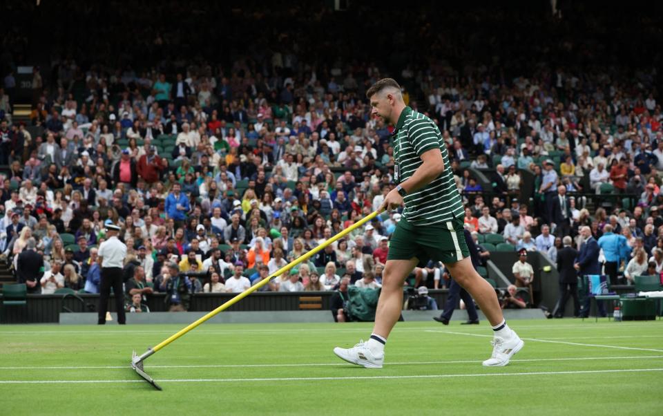 round staff cleans centre court during the second round match between Spain's Rafael Nadal and Lithuania's Ricardas Berankis - REUTERS/Paul Childs