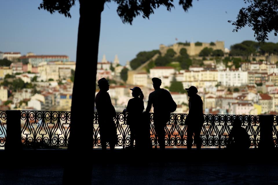 FILE - People stop to look at the view from a public garden in Lisbon's Bairro Alto, or High Quarter, April 17, 2023. Record-breaking April temperatures in Spain, Portugal and northern Africa were made 100 times more likely by human-caused climate change, a new flash study found. (AP Photo/Armando Franca, File)