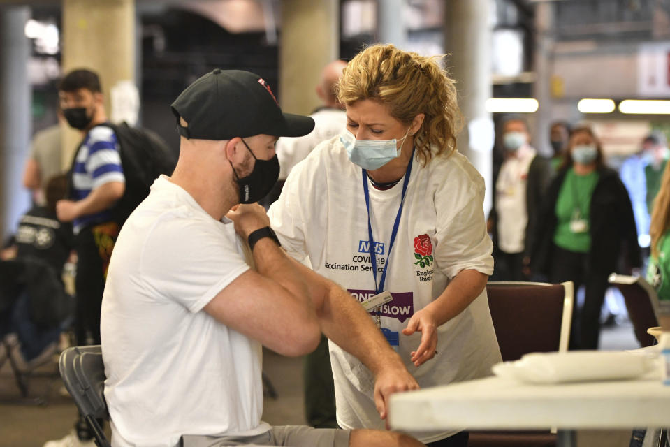 A member of the public prepares to receive a coronavirus vaccination at a surge vaccine operation set up at Twickenham rugby stadium, south-west London, Monday May 31, 2021. Up to 15,000 doses of vaccine are ready to be administered at the walk-in centre which has been set up for residents of north-west London in response to an increase in the number of coronavirus cases in the area. (Dominic Lipinski/PA via AP)