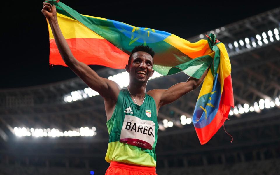 Selemon Barega waves the Ethiopian flag - REUTERS