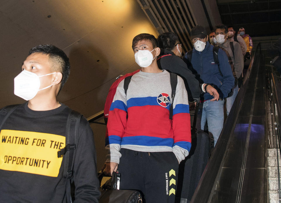 In this photo released by Xinhua News Agency, members of Wuhan FC, then known as Wuhan Zall, arrive at the Wuhan railway station on their return in Wuhan in central China's Hubei Province on April 18, 2020. The club endured quite an ordeal last year after first being stranded in Spain on a preseason tour as its home city was overrun by the virus, and then fleeing the country just before the outbreak hit Europe hard. (Xiao Yijiu/Xinhua via AP)