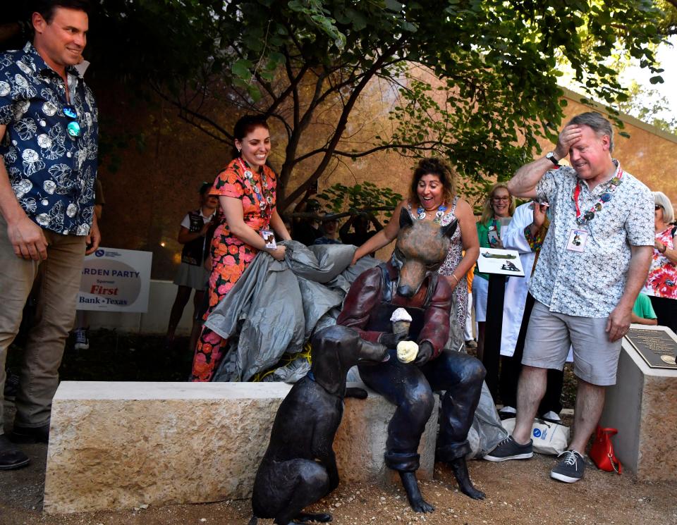 Illustrator and author Brian Lies reacts upon first seeing sculptor Steven Neves’ (far left) rendering of Lies’ character of Evan the fox during the unveiling of the work Thursday. Lies is the honoree for this year's Children’s Art and Literacy Festival, which began Thursday with a costume contest and downtown parade.