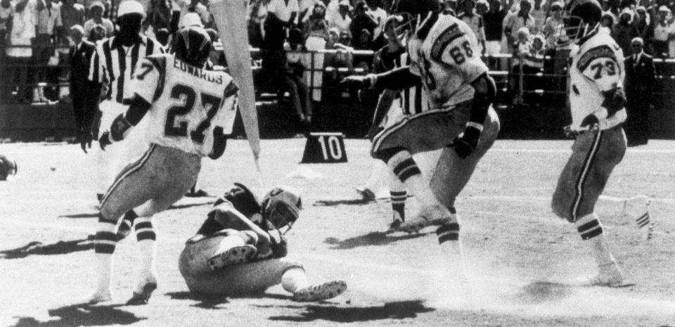 FILE - In this Sept. 11, 1978, file photo, Oakland Raiders' Dave Casper falls in the endzone for a touchdown against the San Diego Chargers on the final play of a football game, in San Diego. The stage was set in San Diego when the Raiders had the ball at the Chargers 14, trailing 20-14 with 10 seconds left. Ken Stabler dropped back to pass and was pressured by Chargers linebacker Woodrow Lowe. With nowhere to throw the ball, Stabler either fumbled or pushed the ball forward on purpose, depending on which side of the rivalry is telling the story. Teammate Pete Banaszak then knocked the ball further ahead from about the 13-yard line as it rolled toward the end zone. Tight end Dave Casper kicked the ball forward at the 5 and then fell on it in the end zone with no time remaining. (Thane McIntosh/The San Diego Union-Tribune via AP)