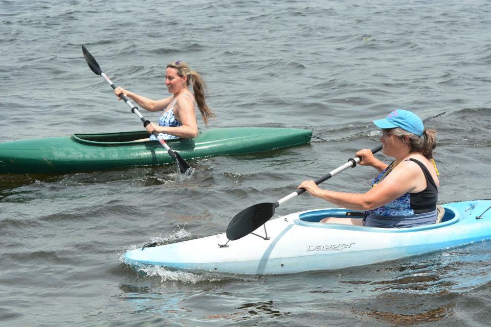 Sisters Sandy Dondero, left, and Dee Ethier, both of Norwich stay cool in their kayaks Tuesday at Gardner Lake in Salem. Admission is free for in-state residents.