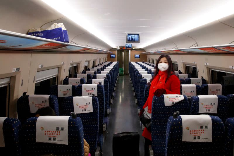 A woman wears a face masks as she travels on a high-speed train near Jiujiang