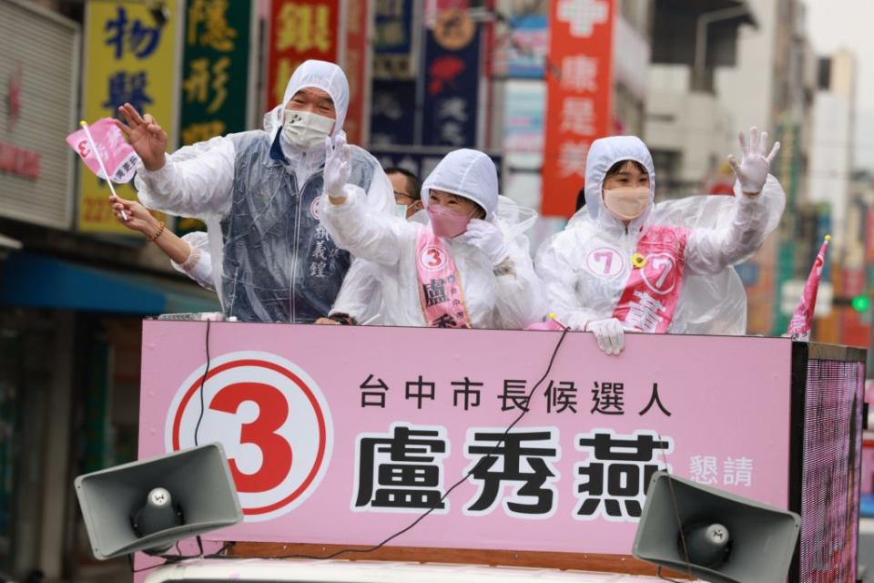 爭取連任的台中市長盧秀燕穿著雨衣在大雨中車隊掃街，支持者熱情揮手，手比三號ＯＫ手勢。（記者徐義雄攝）