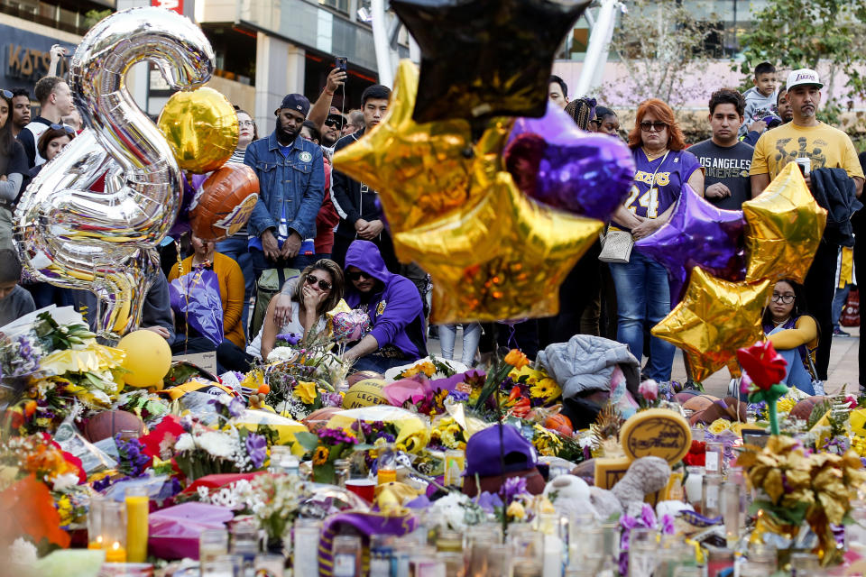 FILE - In this Jan. 28, 2020, file photo, fans pay respect at a memorial for Kobe Bryant near Staples Center in Los Angeles. Bryant, the 18-time NBA All-Star who won five championships and became one of the greatest basketball players of his generation during a 20-year career with the Los Angeles Lakers, died in a helicopter crash Sunday. (AP Photo/Ringo H.W. Chiu, File)