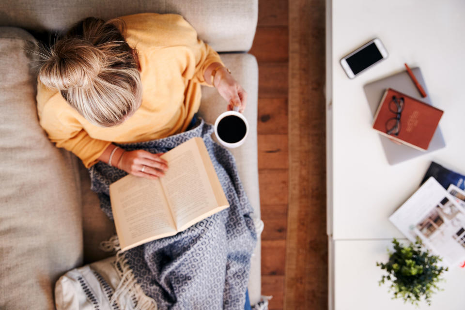 A woman reading on the couch from above.