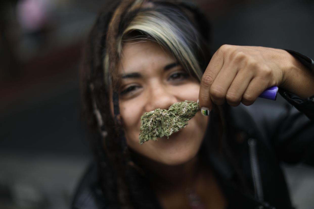 A woman shows a marijuana bud during a sit-in organised by the Mexican Cannabis Movement ‘Planton 420’ outside the Supreme Court of Justice of the Nation (SCJN), in Mexico City, Mexico, 28 June 2021 (EPA)