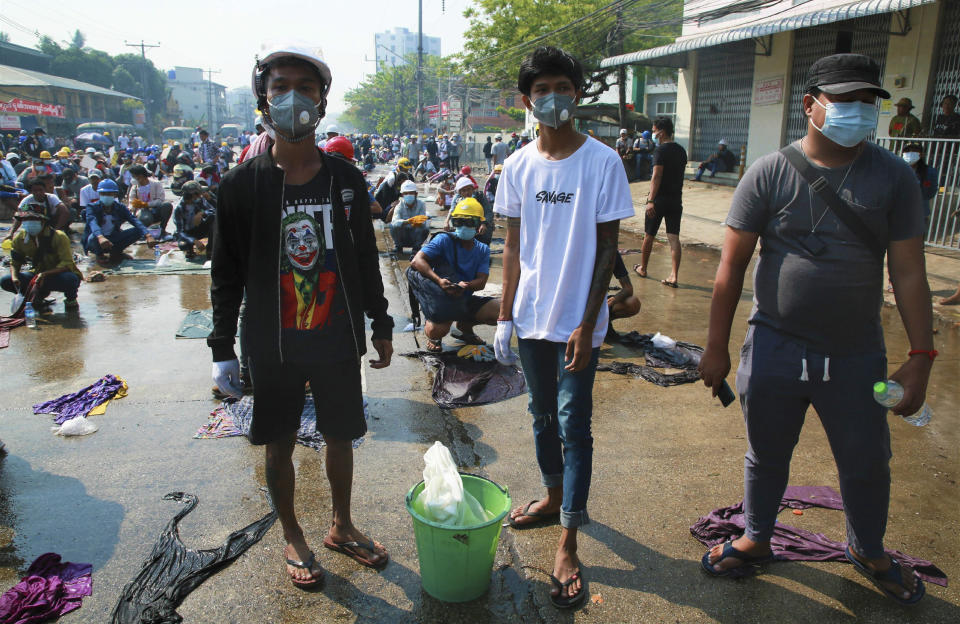 Anti-coup protesters prepare water and wet cloths to help extinguish tear gas canisters during a demonstration in Yangon, Myanmar, Saturday, March 6, 2021. Security forces in Myanmar used force again Saturday to disperse anti-coup protesters, a day after the U.N. special envoy urged the Security Council to take action to quell junta violence that this week left about 50 peaceful demonstrators dead and scores injured. (AP Photo)