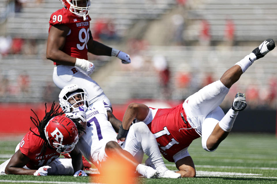 Northwestern running back Anthony Tyus III (7) is tackled by Rutgers defensive lineman Cam'Ron Stewart (11) and Flip Dixon during the second half of an NCAA college football game, Sunday, Sept. 3, 2023, in Piscataway, N.J. (AP Photo/Adam Hunger)