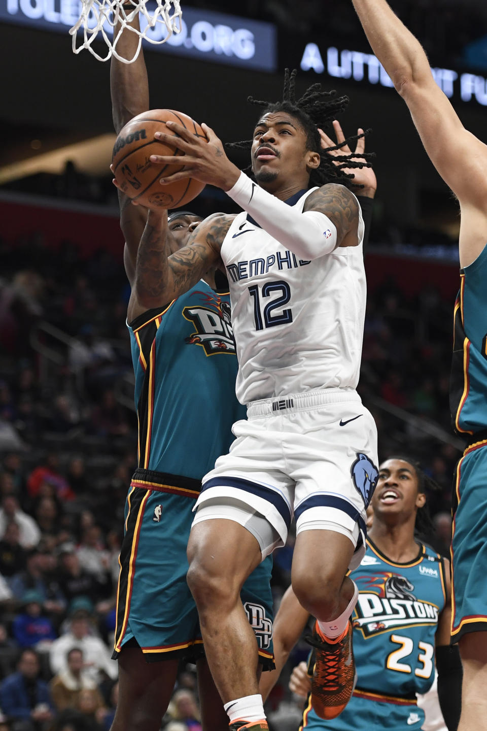 Memphis Grizzlies guard Ja Morant (12) drives to the basket past Detroit Pistons center Jalen Duren during the first half of an NBA basketball game, Sunday, Dec. 4, 2022, in Detroit. (AP Photo/Jose Juarez)